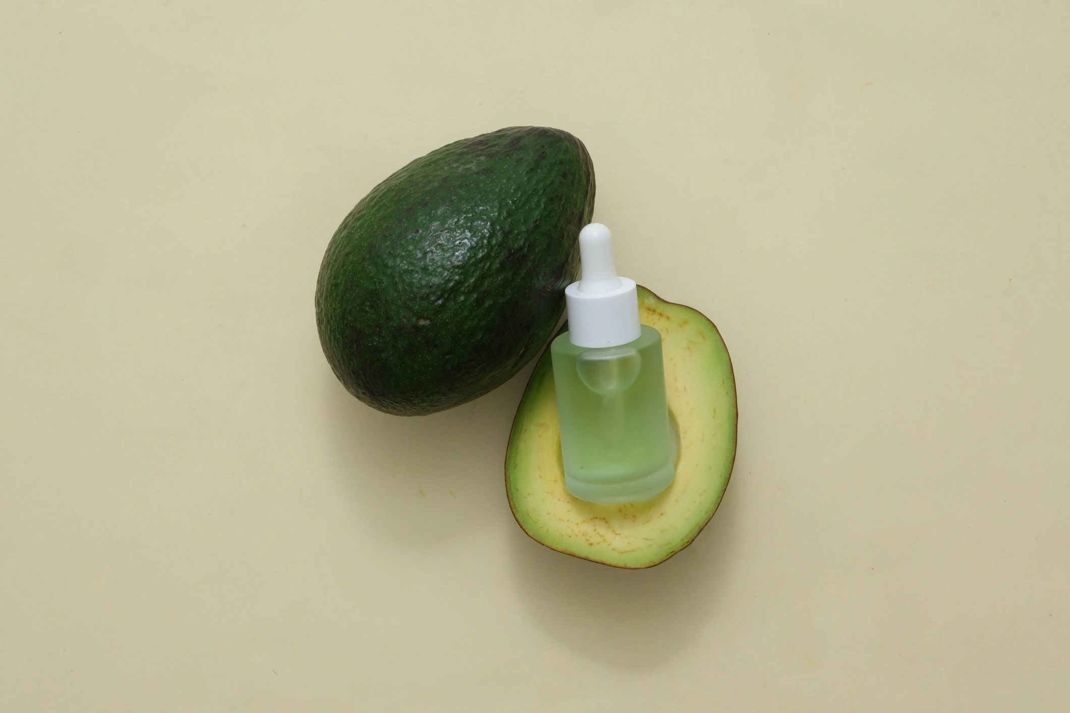 Skincare concept with avocado slices and dropper bottle