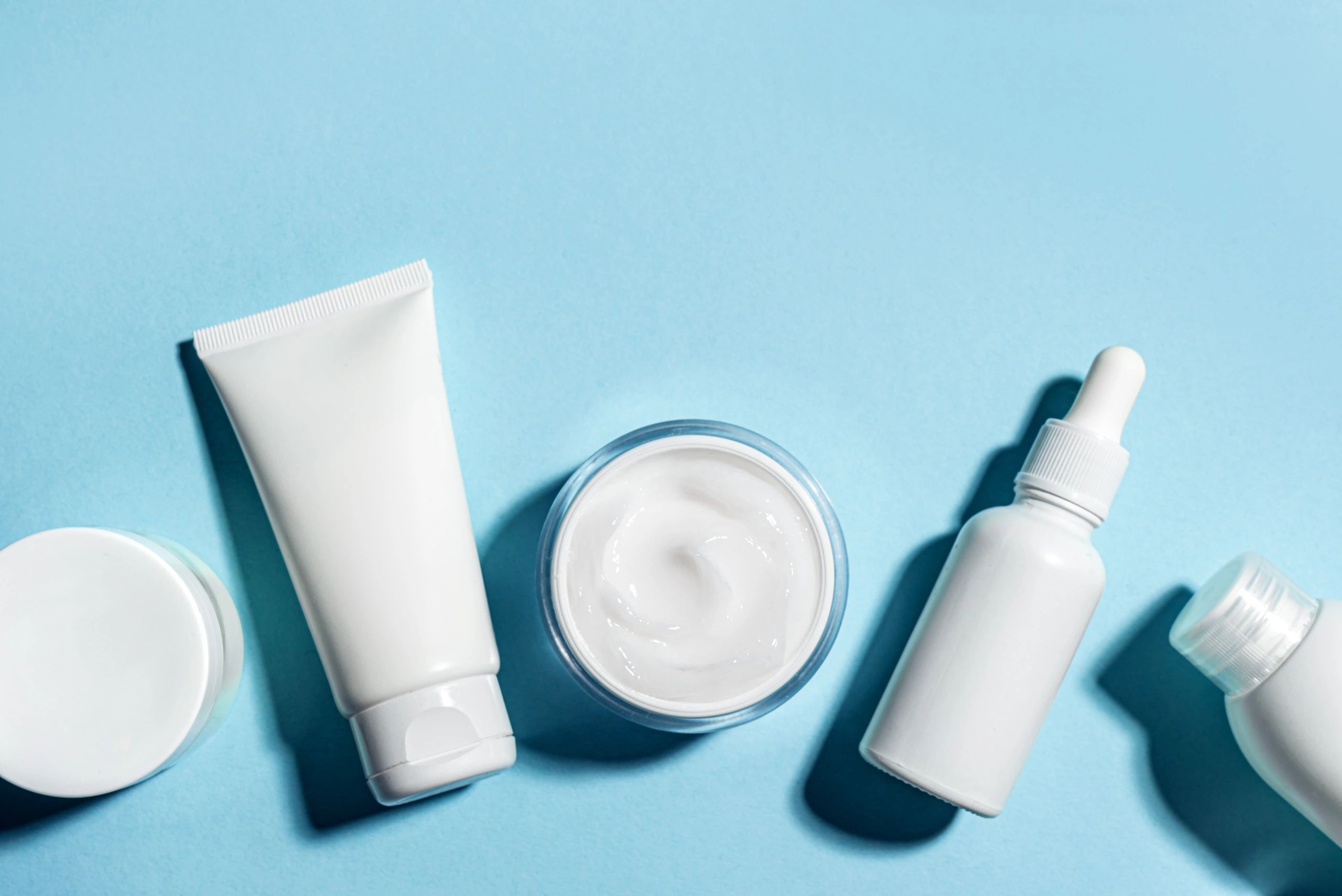 Minimal cosmetic containers arranged on a clean background