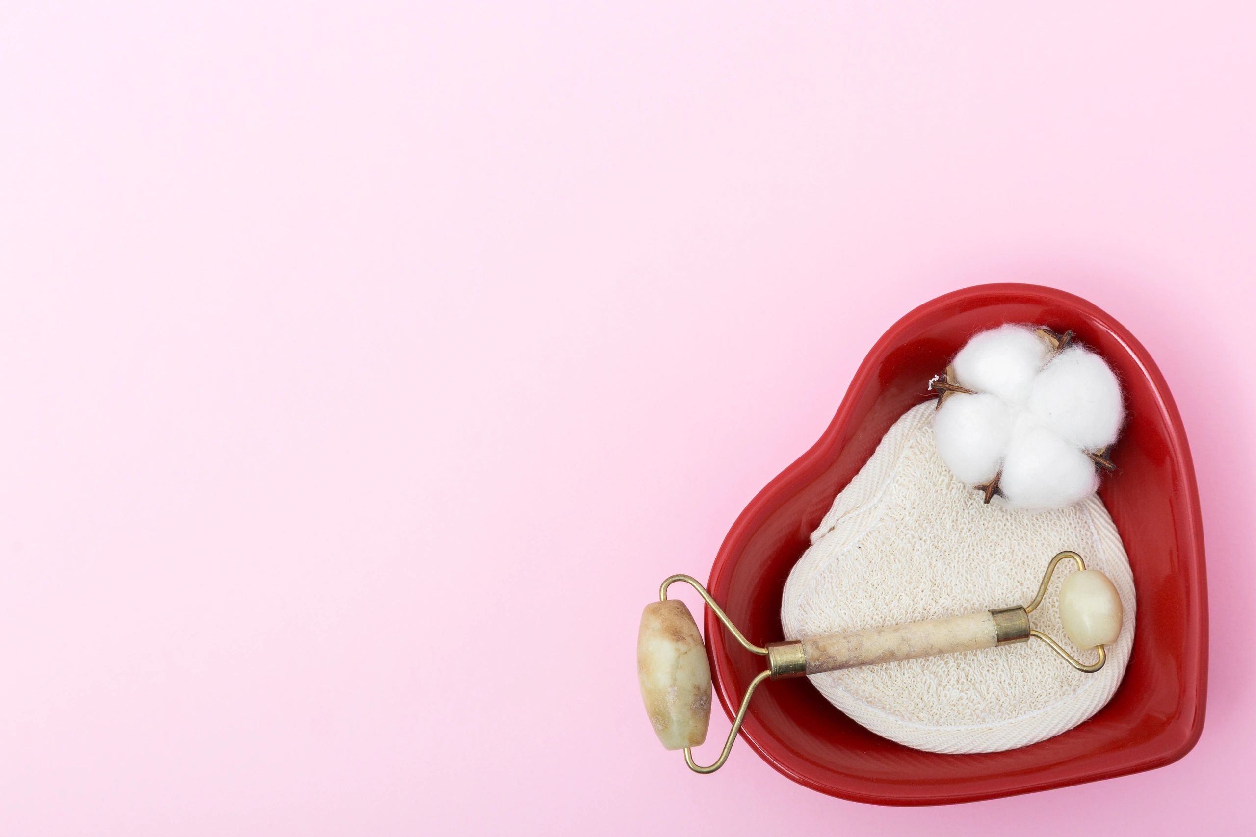 Self-care flat lay with cotton pads and jade roller